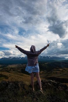 Woman with flashlight in summer Altai mountains in Kurai steppe