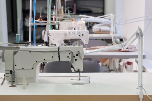 Row of sewing machines in empty atelier studio or tailor shop