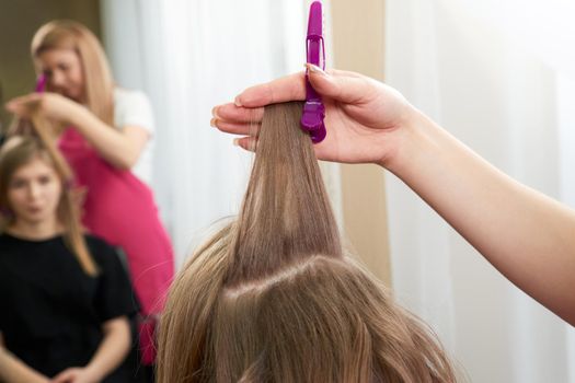 Hairdresser styling hair of a client in a beauty salon