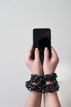 Close-Up Of Person Holding Mobile Phone And Chain