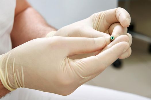 Closeup view of dentist holding dental implant in medical clinic