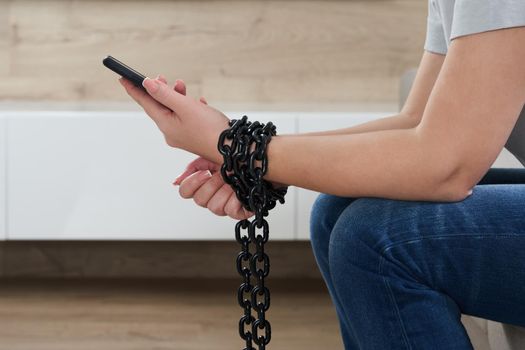 Close-Up Of Person Holding Mobile Phone And Chain