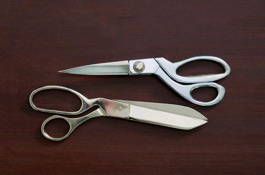 Group of sewing objects lying flat on a black chalkboard background. Horizontal background for ad or packaging.