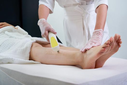 Female legs, woman in professional beauty clinic during laser hair removal
