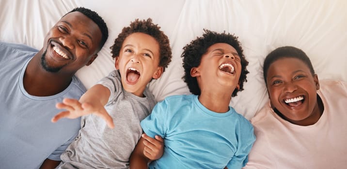 Laugh, happy and relax with black family in bedroom for bonding, wake up and morning routine from top view. Smile, funny and cute with parents and children at home for calm, weekend and quality time.