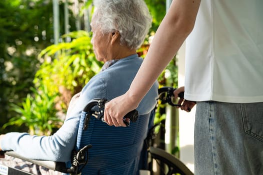 Caregiver help and care Asian senior woman patient sitting on wheelchair to ramp in nursing hospital, healthy strong medical concept.