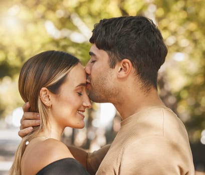 Kiss, love and romance with a couple bonding outdoor during a date on a summer day. Happy, trust and smile with a young man and woman kissing outside together while dating or being romantic.