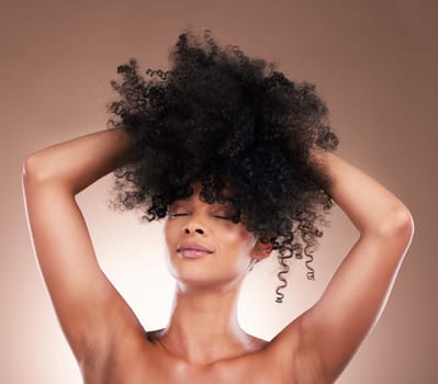 Natural hair, black woman with beauty and face, haircare and cosmetics with satisfaction on studio background. Female is content, arms and cosmetic care with curly hairstyle, texture and skincare.