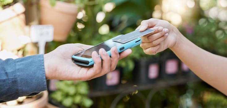 Hands, payment and credit card with a customer using NFC technology to make a purchase at a florist. Money, finance and retail with a female consumer shopping for plants or flowers for gardening.