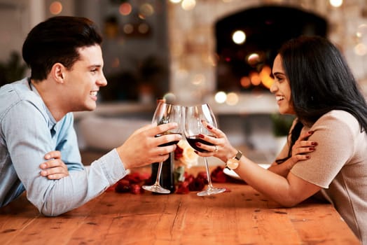 Love, wine and couple cheers on valentines day date at home with smile, romance and bokeh. Date night, man and woman at table in living room, valentine celebration and happy relationship together