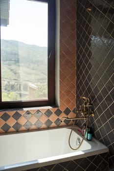 Bathroom with gold faucet and vintage-style shower next to the window. High quality photo