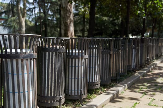 Public rubbish bins standing in a row in the park. High quality photo