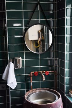 Stylish modern bathroom interior with a mirror and a washbasin in the form of a wooden barrel. High quality photo