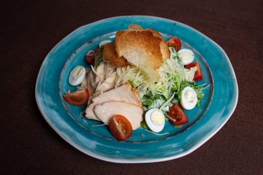 top view of Caesar salad with chicken, fresh lettuce leaves and baked bread.