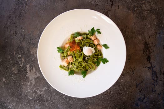 top view pasta with salmon and red caviar and greens in a white plate.