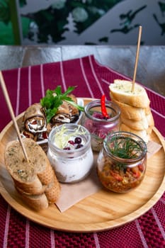 top view of assorted snacks in jars on a wooden stand on the table.