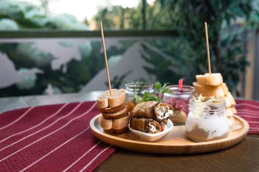 assorted snacks in jars on a wooden stand on the table.