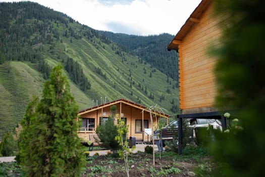 a wooden house outside the city in a mountainous area among trees.