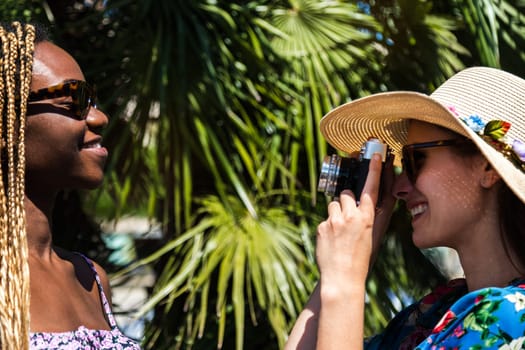 Young woman taking picture of female friend during summer vacation. Summer concept.