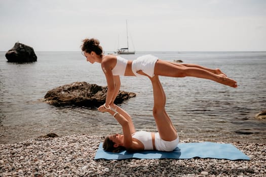 Woman sea yoga. Back view of free calm happy satisfied woman with long hair standing on top rock with yoga position against of sky by the sea. Healthy lifestyle outdoors in nature, fitness concept.