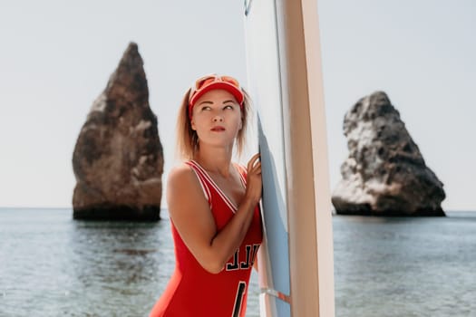 Close up shot of beautiful young caucasian woman with black hair and freckles looking at camera and smiling. Cute woman portrait in a pink bikini posing on a volcanic rock high above the sea