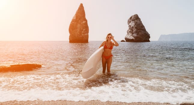 Close up shot of beautiful young caucasian woman with black hair and freckles looking at camera and smiling. Cute woman portrait in a pink bikini posing on a volcanic rock high above the sea