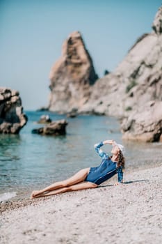 Young woman with black hair, fitness instructor in pink sports leggings and tops, doing pilates on yoga mat with magic pilates ring by the sea on the beach. Female fitness daily yoga concept