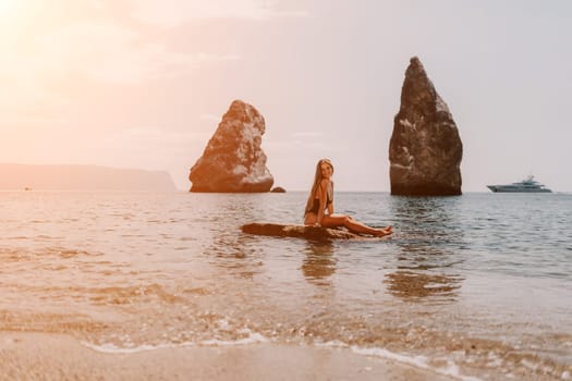 Woman travel sea. Young Happy woman in a long red dress posing on a beach near the sea on background of volcanic rocks, like in Iceland, sharing travel adventure journey