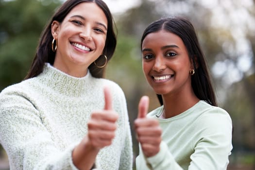 Young women, thumbs up and university students happy for education or success or like their school study as winning friends. Agreement, yes and and female scholars smile for achievement or on campus.