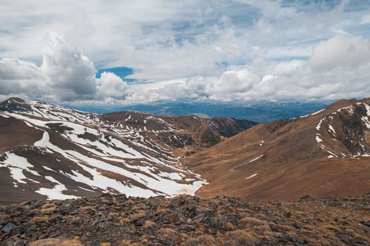 Fascinating view of the steep snowy slopes in the Pyrenees mountains on a cloudy spring sky. Spanish and French mountain nature concept. Copyspace.