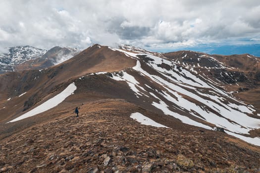 Stunning view of the steep snowy mountain ranges of the Pyrenees on a spring day on a cloudy sky. Travel concept for outdoor enthusiasts and skiers. Copyspace.