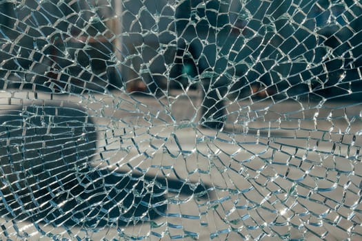 Cracked glass-like surface with intricate spider web pattern on a black background.