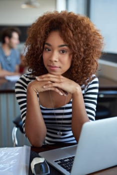 My work makes me happy. a young businesswoman using wireless technology in an office