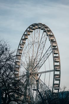 Experience the thrill of riding a giant ferris wheel in an amusement park. Surrounded by trees and the open sky, its a perfect spot for recreation.