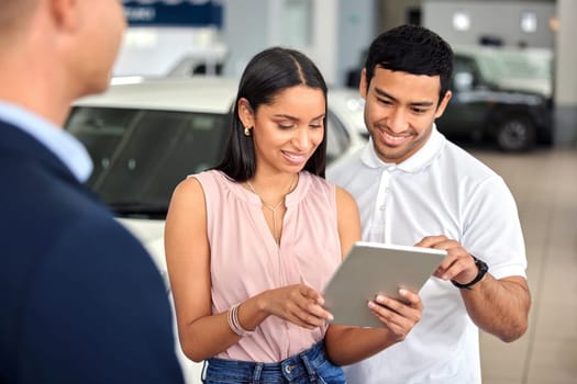 Tablet, car and showroom with couple and salesman for vehicle shopping, test drive and consulting. Auto, transportation and purchase with man and woman in dealership for insurance, sale and motor.
