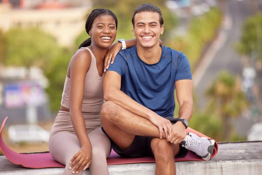 Fitness, yoga and portrait of couple in city on break after stretching, training or workout. Love, interracial couple and man and woman sitting outdoors on mat after pilates exercise for wellness