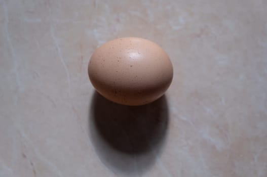 one chicken egg on brown background. breakfast food