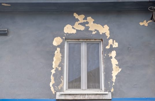 old window in the old wall. facade of vintage window. shell paint around window. aged window