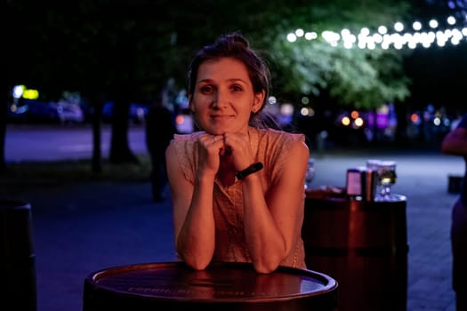 Young beautiful woman smilimg and posing over night city dramatic red and blue neon background