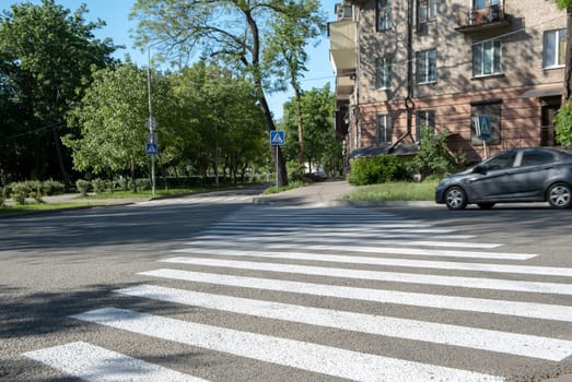 crosswalk on the road. car crossing a crosswalk.