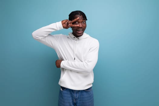 joyful coquettish dark-skinned European young brunette man in a white hoodie.