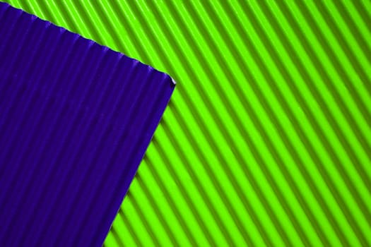 Diagonally ribbed cardboard with the colors neon green and deep purple. Meant as background