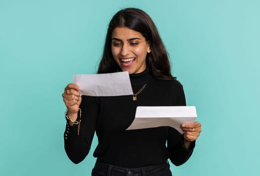 Pretty indian woman open envelope take out letter reads it feel happy. Hindu girl career growth advance promotion, bank loan approve, monetary award, long-awaited invitation great news, lottery win