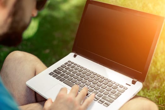 Top view male hands using notebook outdoors in urban setting while typing on keyboard, businessman freelancer working on computer while sitting on city park bench, tourist working on laptop, filter. Sun flare