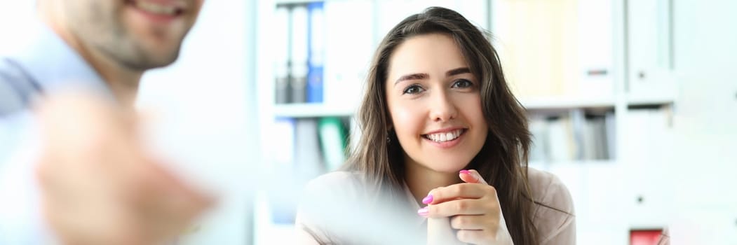 Portrait of successful entrepreneur in conference room holding paper document and smiling at camera. Business meeting and partnership concept