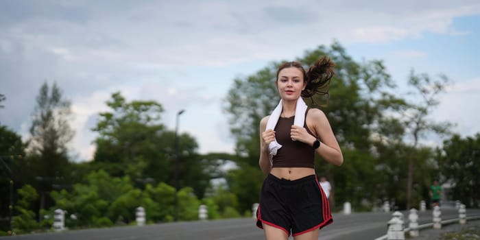 Young attractive beautiful athletic runner woman runs in the green park jogging. Healthy and active lifestyle concept.