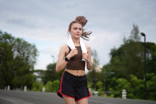 Young attractive beautiful athletic runner woman runs in the green park jogging. Healthy and active lifestyle concept.