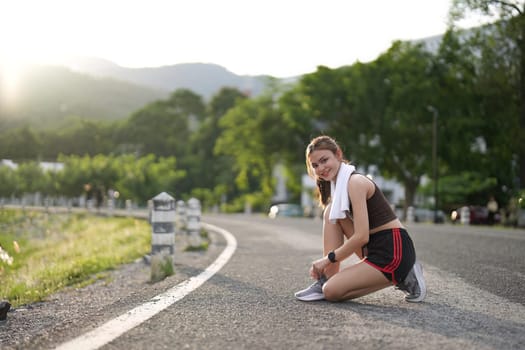 Running shoes. close up female athlete tying laces for jogging on road. Runner ties getting ready for training. Sport lifestyle. copy space.