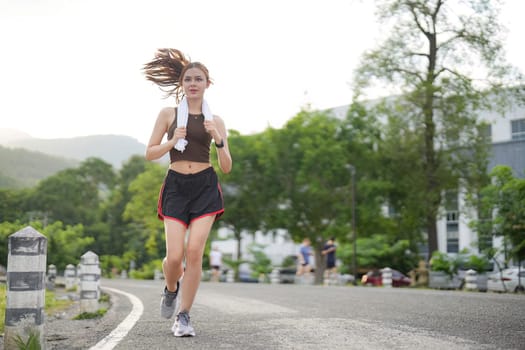 Young attractive beautiful athletic runner woman runs in the green park jogging. Healthy and active lifestyle concept.