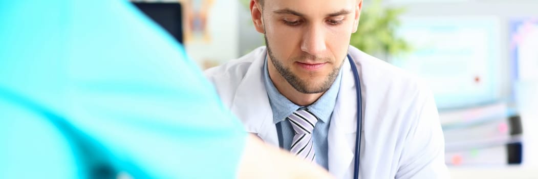 Doctor talks and listens to patient in clinic. Male conversation with urologist concept